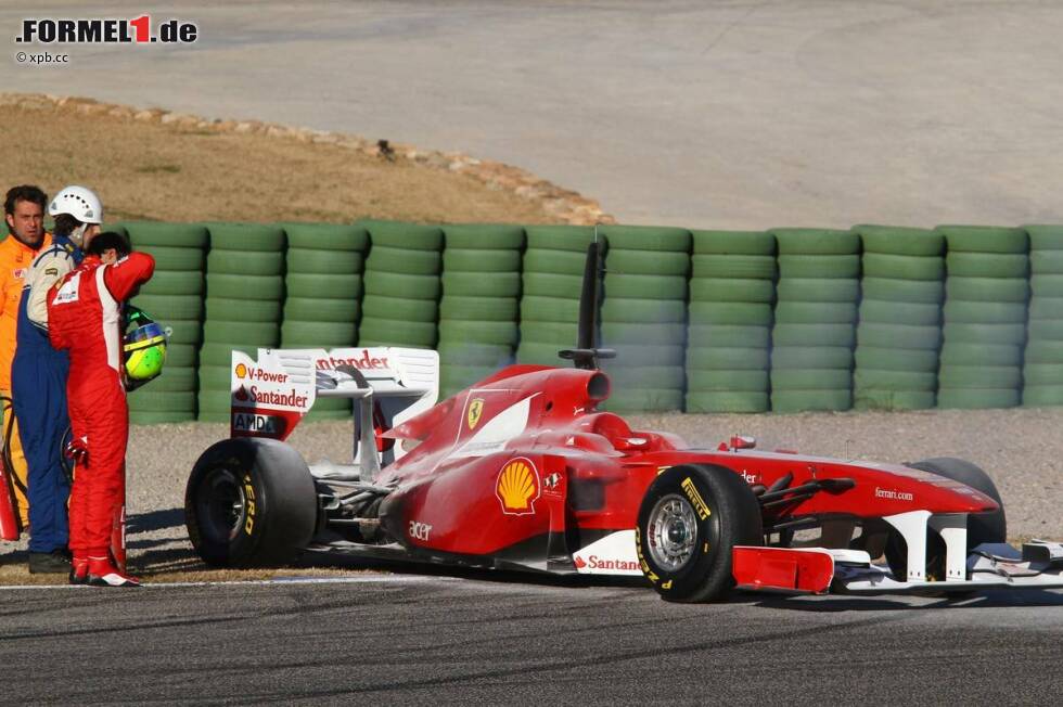 Foto zur News: Felipe Massa betrachtet den Schaden am Ferrari