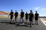 Foto zur News: Romain Grosjean (Lotus) geht mit seiner Crew die Strecke ab