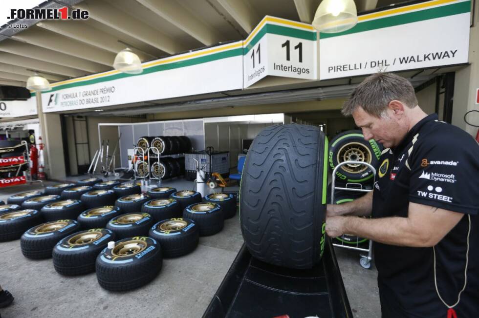 Foto zur News: Lotus-Mechaniker arbeitet mit den Pirelli-Reifen