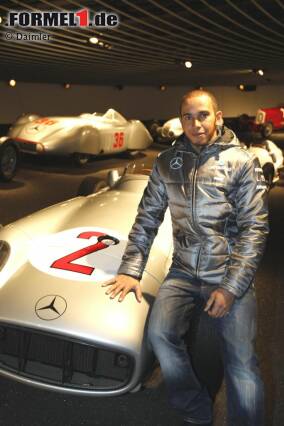 Foto zur News: Lewis Hamilton posiert auf einem historischen Silberpfeil