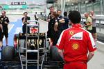 Foto zur News: Ferrari-Mechaniker schaut sich den Lotus E21 an