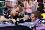 Foto zur News: Sebastian Vettel (Red Bull) erklärt WRC-Star Sebastien Ogier (Volkswagen) seinen Arbeitsplatz