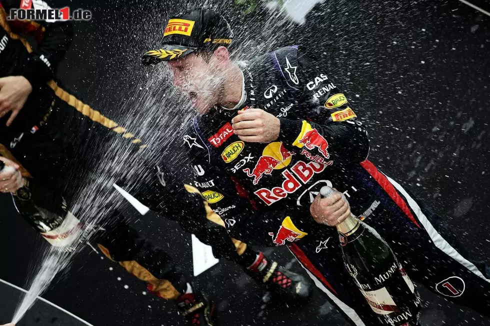 Foto zur News: Auch Sebastian Vettel steckt bei der Sektdusche kräftig ein