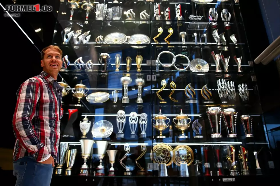 Foto zur News: Sebastian Vettel vor dem Schrank mit den Pokalen