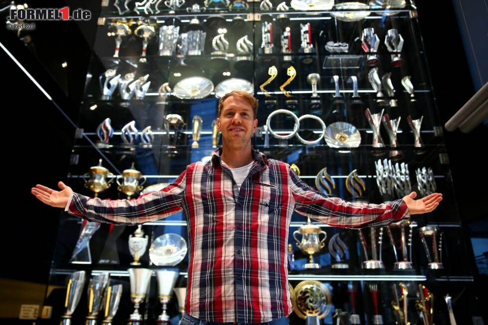 Foto zur News: Sebastian Vettel vor dem Schrank mit den Pokalen