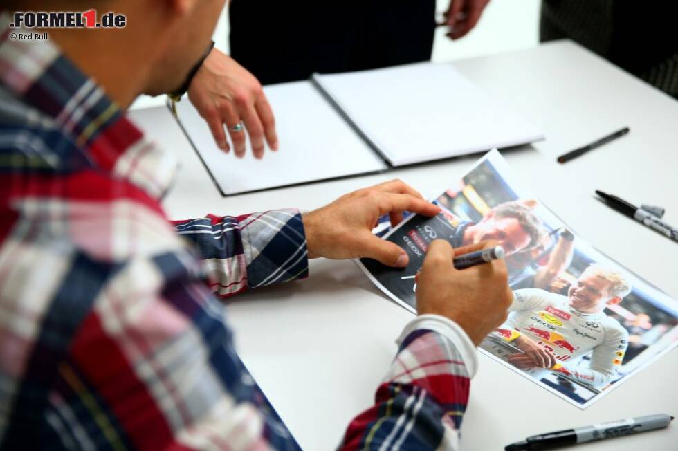 Foto zur News: Sebastian Vettel schreibt Autogramme