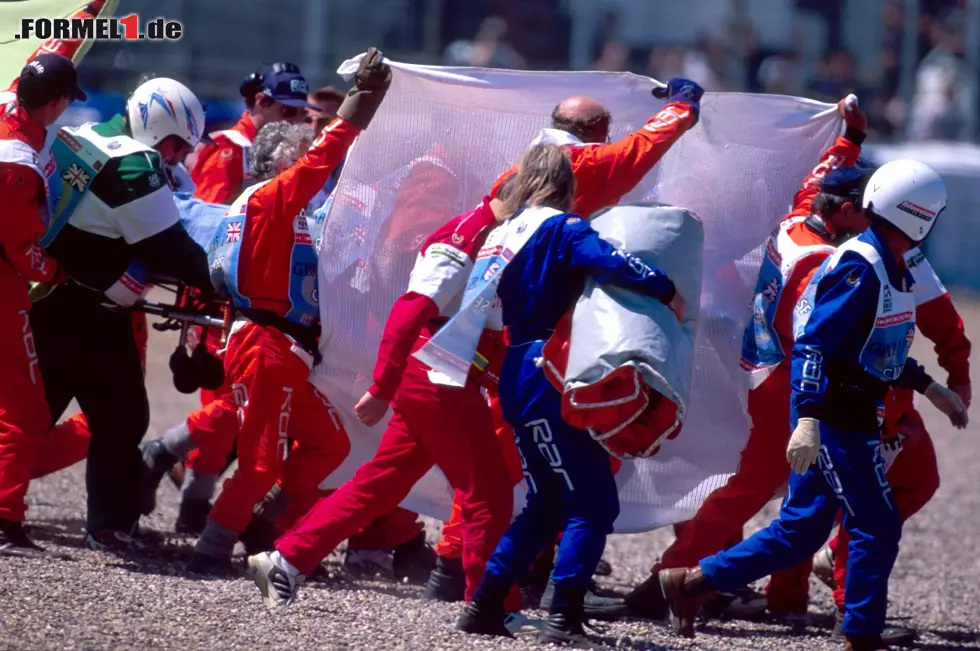 Die Streckenposten erkennen den Ernst der Lage und schirmen neugierige Fotografen und TV-Kameras mit einem großen Tuch ab. In diesen Momenten verliert Schumacher das Bewusstsein. Foto zur News: Die Streckenposten erkennen den Ernst der Lage und schirmen neugierige Fotografen und TV-Kameras mit einem großen Tuch ab. In diesen Momenten verliert Schumacher das Bewusstsein.