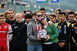 Foto zur News: Gedenkminute für den verstorbenen Anthoine Hubert. Seine Mutter und sein Bruder halten den Helm des französischen Formel-2-Fahrers.