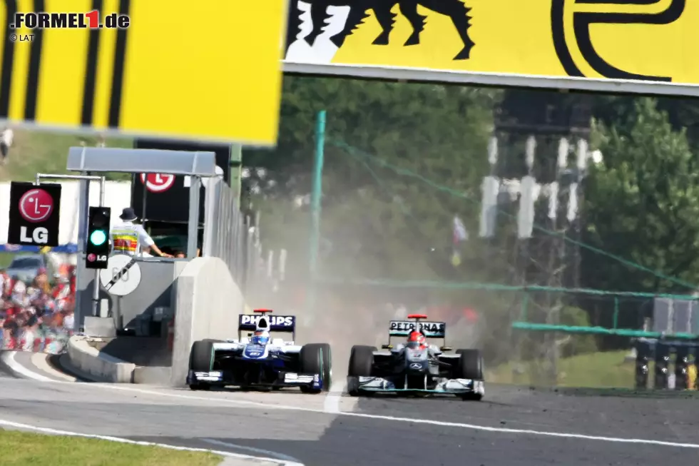 Der Williams von Barrichello zwängt sich bei mehr als 250 km/h durch die enge Lücke zwischen Boxenmauer und Schumachers Mercedes. Foto zur News: Der Williams von Barrichello zwängt sich bei mehr als 250 km/h durch die enge Lücke zwischen Boxenmauer und Schumachers Mercedes.