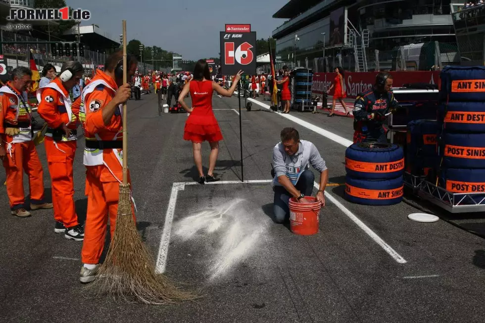 Foto zur News: Auch alte Besen kehren gut. Vor dem Start in den Großen Preis von Italien wird der Asphalt am Startplatz des Schweizers Sébastien Buemi mit einfachsten Mitteln gereinigt.