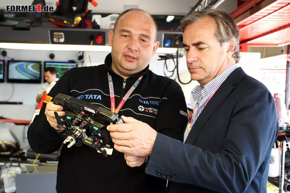 Foto zur News: Alles, was im spanischen Motorsport Rang und Namen hat, kommt zur Formel 1 nach Barcelona. So auch Rallye-Legende Carlos Sainz, die sich von HRT-Teamchef Colin Kolles das Lenkrad erklären lässt.