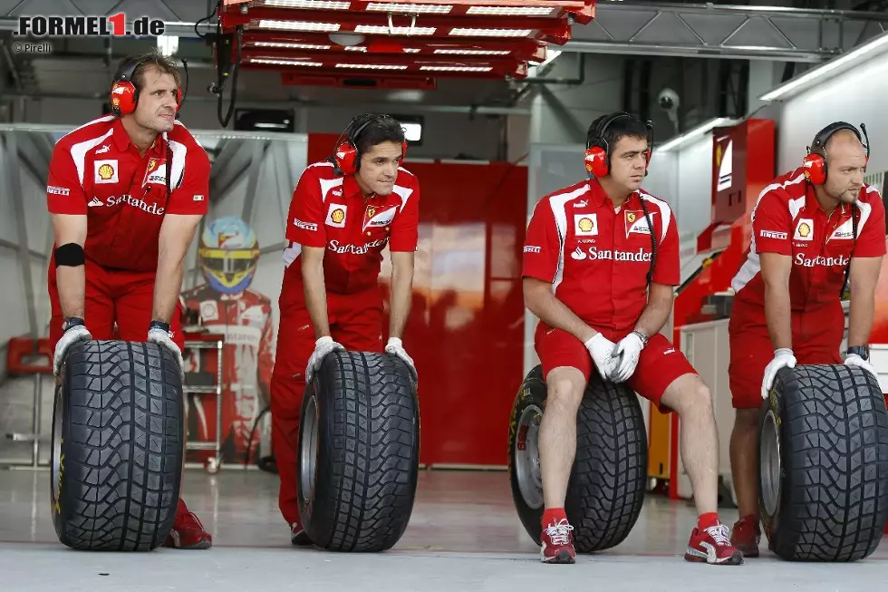 Foto zur News: Ferrari-Mechaniker warten mit Pirelli-Reifen auf ihren Einsatz.