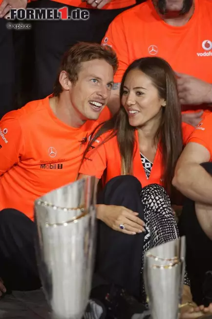 Foto zur News: Jenson Button, im orangefarbenen McLaren-Sieger-T-Shirt und mit Freundin Jessica Michibata, gratuliert seinem Teamkollegen und feiert mit.