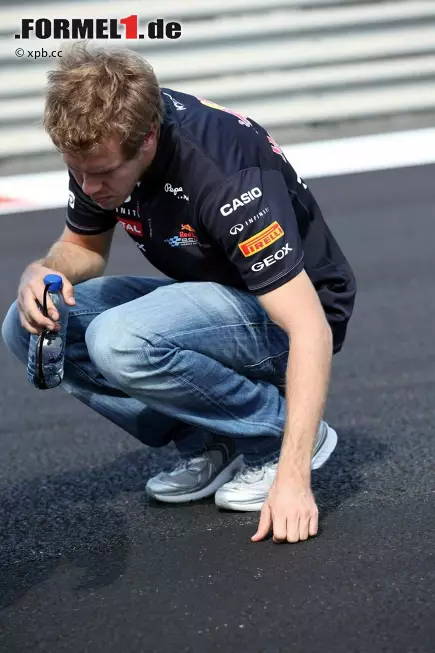 Foto zur News: Sebastian Vettel prüft den Asphalt. Ob er schon am Donnerstag gewittert hat, dass sein Reifen darauf platzen könnte?
