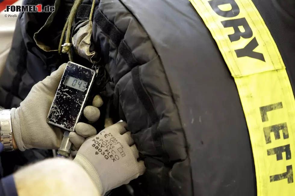 Foto zur News: Ein Pirelli-Mechaniker misst den Luftdruck...