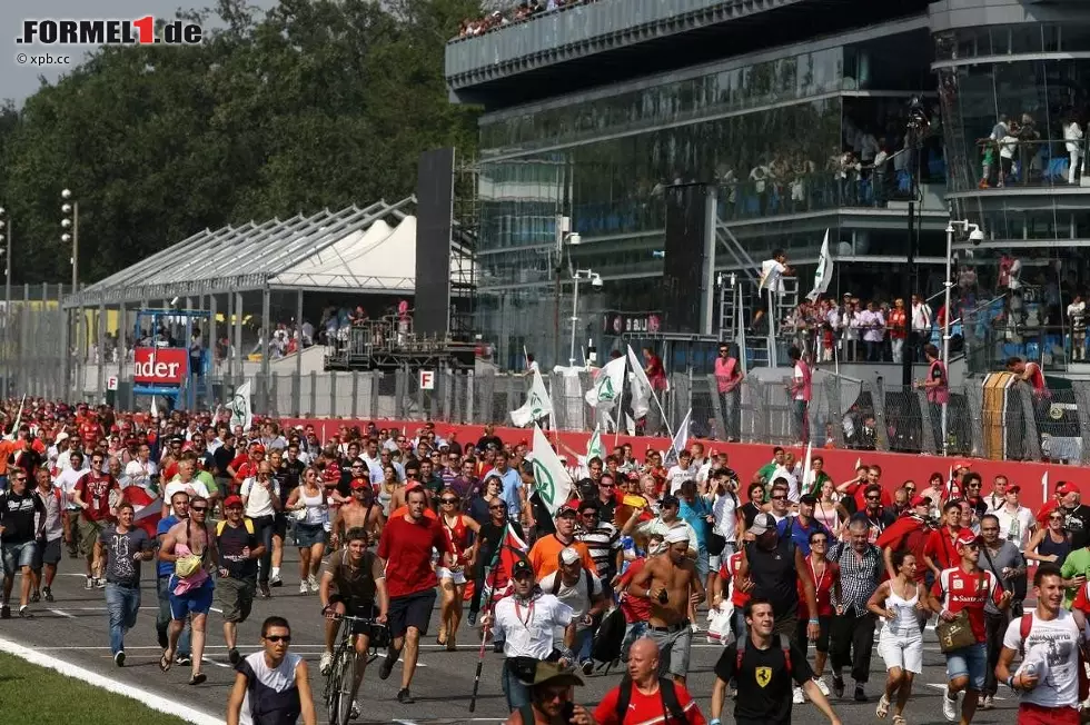 Typisch Monza: Am Ende eines Grand Prix strömen die Fans in richtung Siegerehrung. Kurios ist allerdings der Mann, der den Weg mit dem Fahrrad zurücklegt. Wo hat er den Drahtesel während des Rennens gehabt? Unter seinem Tribünensitz? Foto zur News: Typisch Monza: Am Ende eines Grand Prix strömen die Fans in richtung Siegerehrung. Kurios ist allerdings der Mann, der den Weg mit dem Fahrrad zurücklegt. Wo hat er den Drahtesel während des Rennens gehabt? Unter seinem Tribünensitz?