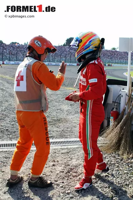Foto zur News: Fernando Alonso versteht die Welt nicht mehr: Zweite Nullnummer der Saison - und wieder von einem Lotus abgeschossen! Was ihm der japanische Streckenposten zu erklären versucht, ist dem Ferrari-Piloten in jenem Moment wahrscheinlich ziemlich egal.