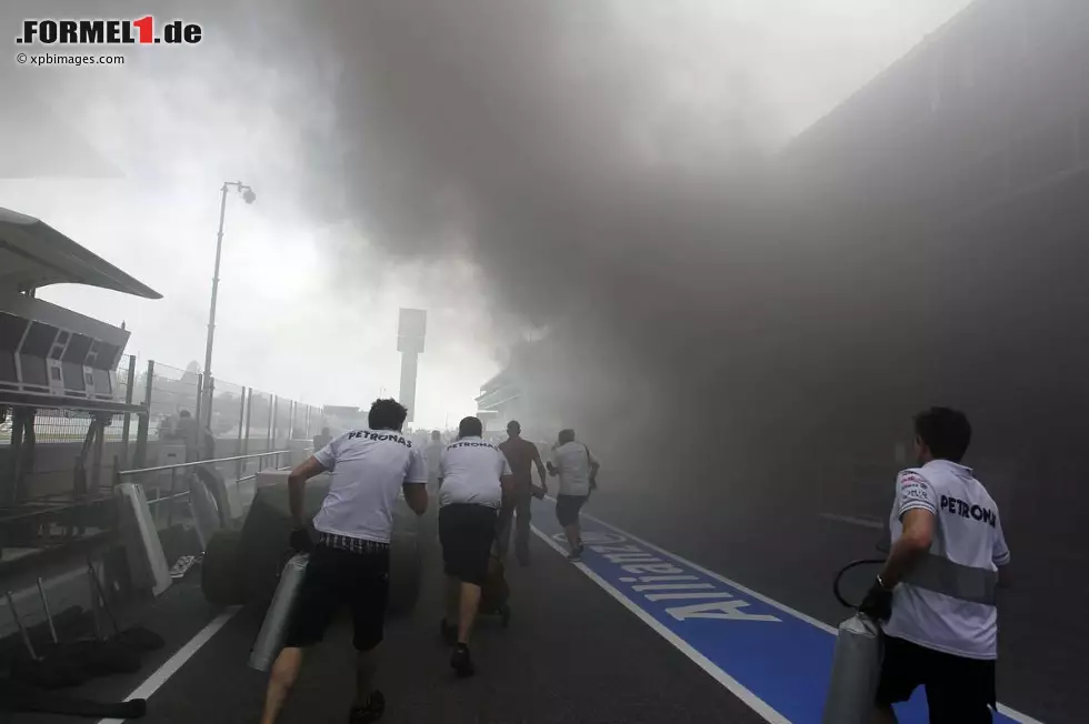 Foto zur News: Mercedes-Mechaniker eilen zu Hilfe und halten sich notdürftig ihre eigenen T-Shirts vors Gesicht, um nicht mit einer Rauchgasvergiftung umzukippen.
