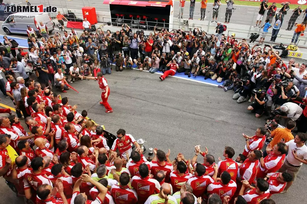 Und so der Blick von "der anderen Seite": Während die Scuderia ausgelassen feiert, drängeln sich dutzende Fotografen um das beste Foto. Alltag für die Medienschaffenden im Paddock. Foto zur News: Und so der Blick von "der anderen Seite": Während die Scuderia ausgelassen feiert, drängeln sich dutzende Fotografen um das beste Foto. Alltag für die Medienschaffenden im Paddock.