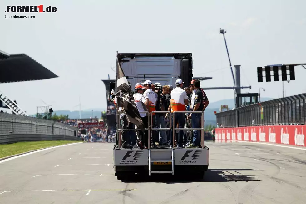 Foto zur News: Tempo 50 statt Tempo 300+: Bei der traditionellen Fahrerparade werden die 22 Fahrer auf einer LKW-Ladefläche den Fans entlang der Strecke präsentiert. Was viele lieber zum Klatsch und Tratsch nutzen, anstelle permanent zu winken. Wenn nicht gerade die TV-Reporterin Tanja Bauer stört...