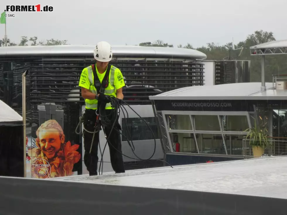 Foto zur News: Und noch ein stiller Held der Formel 1: Selbst bei strömendem Regen beginnt dieser Mitarbeiter mit dem Abbau der McLaren-Infrastruktur. Schließlich soll das Material so schnell wie möglich verladen werden.