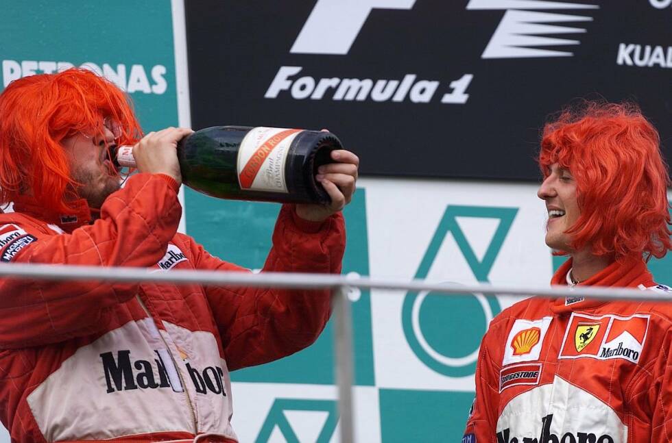 Foto zur News: 2000 platzte endlich der Knoten, und Michael Schumacher holte mit Ferrari endlich den lange ersehnten WM-Titel. Bei der Feier auf dem Siegespodest in Sepang trugen die Ferrari-Triumphatoren rote Perücken, und auch Brawn gönnte sich einen Schluck Champagner. Damit begann in der Formel 1 die