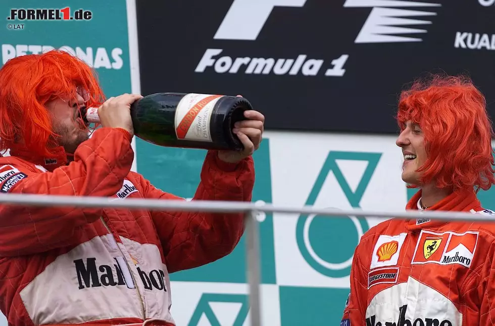 2000 platzte endlich der Knoten, und Michael Schumacher holte mit Ferrari endlich den lange ersehnten WM-Titel. Bei der Feier auf dem Siegespodest in Sepang trugen die Ferrari-Triumphatoren rote Perücken, und auch Brawn gönnte sich einen Schluck Champagner. Damit begann in der Formel 1 die Foto zur News: 2000 platzte endlich der Knoten, und Michael Schumacher holte mit Ferrari endlich den lange ersehnten WM-Titel. Bei der Feier auf dem Siegespodest in Sepang trugen die Ferrari-Triumphatoren rote Perücken, und auch Brawn gönnte sich einen Schluck Champagner. Damit begann in der Formel 1 die