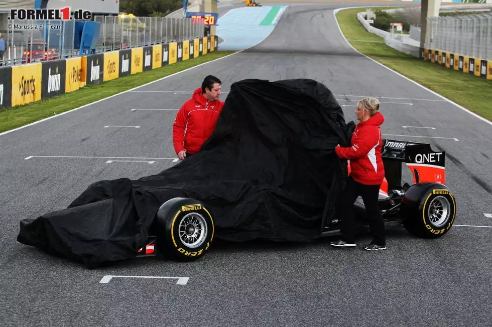 Foto zur News: Relativ schmucklos präsentiert Marussia am Morgen des 5. Februar in Jerez den MR02. Keiner der Fahrer, sondern zwei Mitarbeiter entfernen die Plane vom Auto, mit dem das britisch-russische Team in seine vierte Formel-1-Saison startet. Vorausgegangen war ein turbulenter Winter.