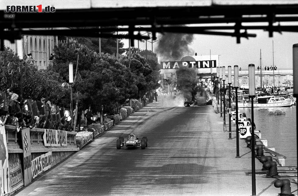 Foto zur News: Das Rennen 1967 in Monaco: Denis Hulme führt vor Lorenzo Bandini. Der rammt die Streckenbegrenzung aus Strohballen, die sich durch das auslaufende Benzin entzünden. Bandini kann nach drei Minuten geborgen werden, stirbt aber kurze Zeit später an seinen schweren Verbrennungen.