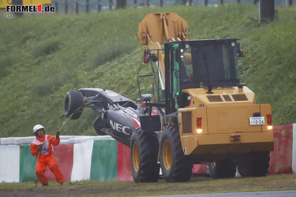 Foto zur News: Mit einem gelben Radlader wird der Sauber von der Unfallstelle weggebracht. Ein Streckenposten stabilisiert mit einem Seil das Auto, damit dieses beim Transport nicht pendelt und zusätzlich beschädigt wird.