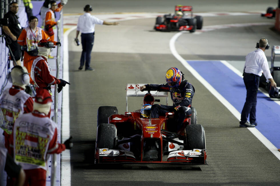 Foto zur News: Aufreger nach Rennende 2013: Fernando Alonso bietet Mark Webber den Seitenkasten seines Ferrari als Rückfahrgelegenheit an. Webber kassiert dafür bereits die dritte Verwarnung der Saison - und wird für das nächste Rennen um zehn Startpositionen strafversetzt. Entscheidend aber nicht die Taxifahrt des Red-Bull-Routiniers an sich, sondern dass er sich den Streckenposten widersetzt, die ihn davor warnen, auf die Strecke zu laufen.