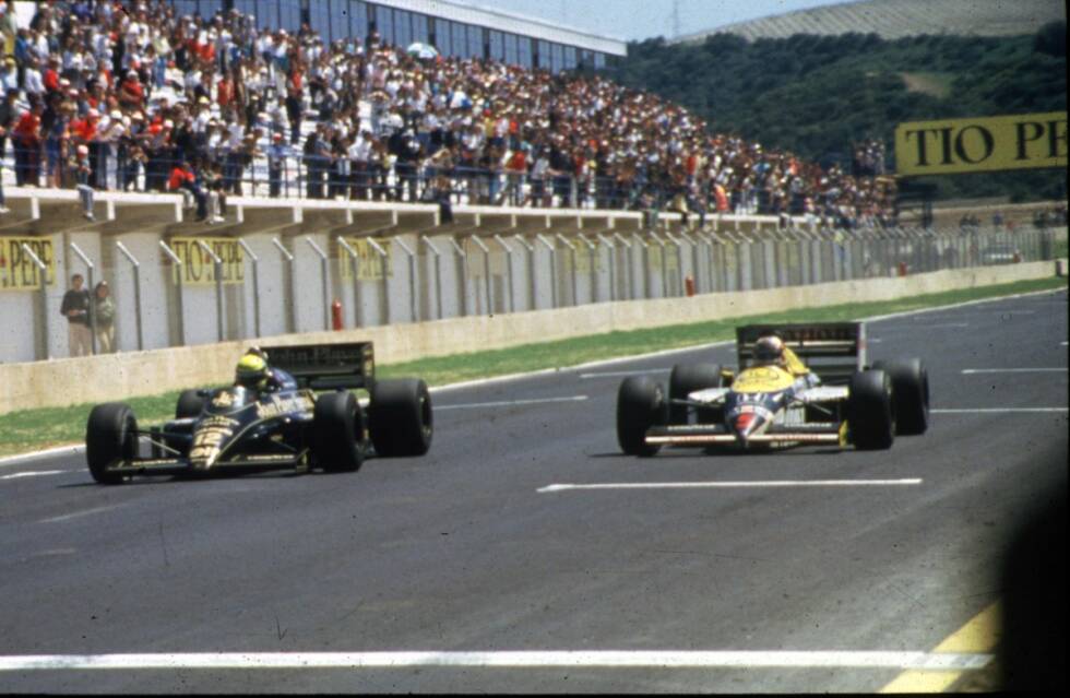 Foto zur News: Das Comeback gibt es erst 1986: in Jerez, und gleich winkt ein Jahrhundert-Duell. Ayrton Senna führt im Lotus auf uralten Reifen, rutscht und driftet, während von hinten der mit neuen Pneus ausgestattete Nigel Mansell im Williams heranfliegt. Der &quot;Löwe&quot; versucht alles, um am Brasilianer vorbeizukommen, doch Senna verteidigt sich virtuos und wirft teilweise radikal die Tür zu. Am Ende rettet er den Wimpernschlag von 0,014 Sekunden Vorsprung über die Linie. Mansell beklagt sich nachher nicht, sondern erfreut sich an der Action: &quot;Wir hätten beide 7,5 Punkte bekommen sollen.&quot;