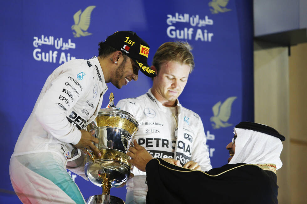 Foto zur News: Ein Bild sagt mehr als 1.000 Worte: Lewis Hamilton holt seinen dritten Siegerpokal im vierten Rennen ab - und Nico Rosberg grübelt mit gesenktem Kopf, wie er vielleicht doch noch Weltmeister werden kann.