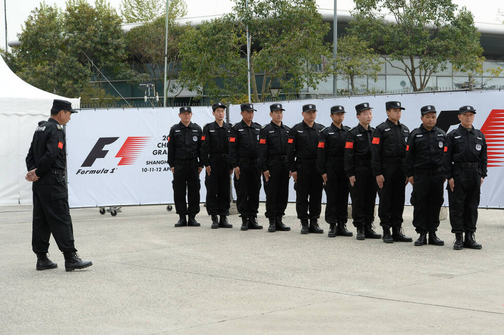 Foto zur News: Wohingegen diese Security-Herren am Freitag ihren großen Auftritt haben, als ein verrückter Fan vor der Nase von Sergio Perez über die Strecke läuft. Der Irre wollte offenbar Vettels Ferrari ausprobieren - und landet stattdessen in den Händen der Polizei.