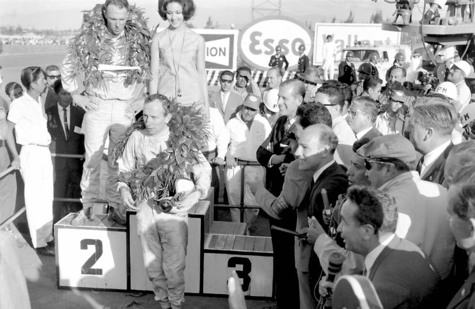 Foto zur News: ... mit einem Sieg mit Hill gleichziehen und im Tie-Break den Titel holen, weil er mehr Saisonsiege vorweist. In der vorletzten Runde aber gibt der Climax-Motor im Lotus von Clark den Geist auf. Abstauber ist Surtees (Foto). Der britische Ferrari-Pilot holt sich mit Platz zwei hinter Sieger Dan Gurney (Brabham) die nötigen Punkte, um sich mit einem Zähler Vorsprung auf Hill den WM-Titel zu sichern.