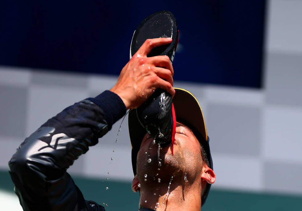 Foto zur News: Die Sache mit den Schuhen wird langsam zum (fragwürdigen) Modetrend. Erst nippt Daniel Ricciardo wieder selbst den Schampus aus dem verschwitzten Puma, was seinen Sponsor sicher freuen wird, ...