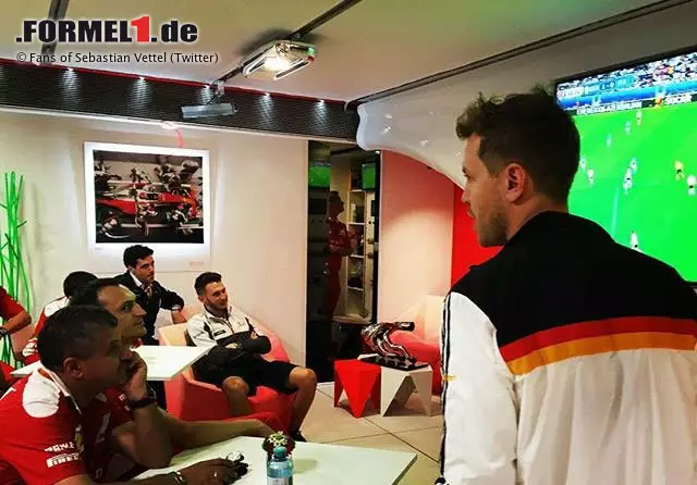 Foto zur News: Ein paar Meter weiter schaut Sebastian Vettel mit Freundin Hanna, Vater Norbert und Mutter Heike bei Ferrari. Als Deutschland zum 1:0 trifft, kommt er mit DFB-Trikot und Tröte bewaffnet zu den Mechanikern runter und zieht diese mit dem Zwischenstand auf. Nur um kurz darauf wieder zum &quot;Inner Circle&quot; zu verschwinden.