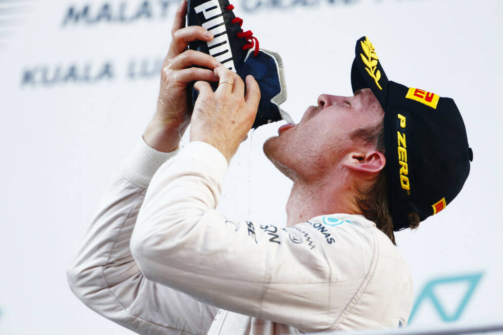 Foto zur News: Dass er den Schampus aus Ricciardos verschwitztem Schuh trinken muss, lässt Rosberg zwar den Kopf schütteln - aber er schluckt das Übel tapfer runter. Und freut sich über seine verbesserte WM-Situation, auch wenn er sagt: &quot;Mir wäre lieber, es wäre anders passiert. Ich weiß, wie mies sich Lewis jetzt fühlen muss.&quot;