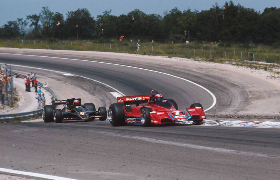 Foto zur News: Frankreich-Grand-Prix 1977: John Watson wehrt sich mit buchstäblich mit Händen und Füßen gegen die Angriffe des Mario Andretti, als ihn sein Alfa-Romeo-Motor im Stich lässt. Ein kurzer Aussetzer reicht, um den Nordiren zurückzuwerfen.
