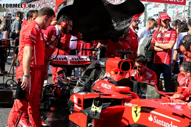 Foto zur News: Bereits vor dem Start zeichnet sich ein Problem am Vettel-Ferrari ab. Eine Zündkerze wird als Fehlerquelle identifiziert. Die Bilder erinnern an Malaysia, ein Ferrari-Sprecher gibt Entwarnung: Reine Sicherheitsmaßnahme. Noch bitterer: In der Hektik bleibt Vettel der Hymnen-Zeremonie fern - und kassiert dafür eine Verwarnung.