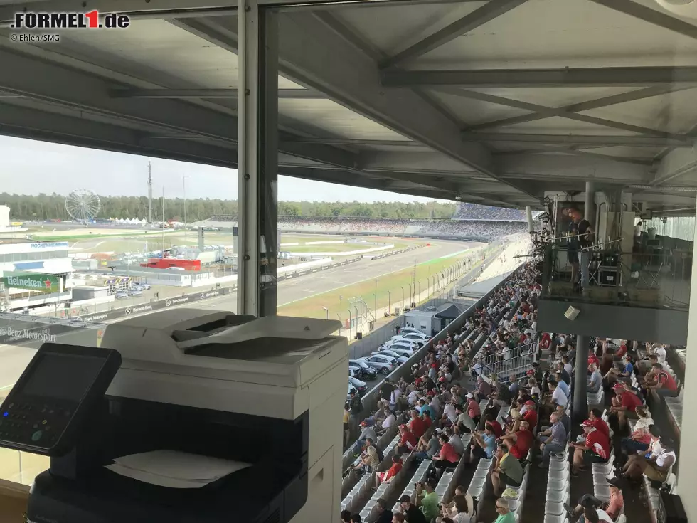 Foto zur News: Der Blick aus dem Seitenfenster in Richtung Südkurve: Aus dem Drucker kommen aktuelle Informationen, von unten sind Fahrgeräusche und Emotionen der Fans zu vernehmen.