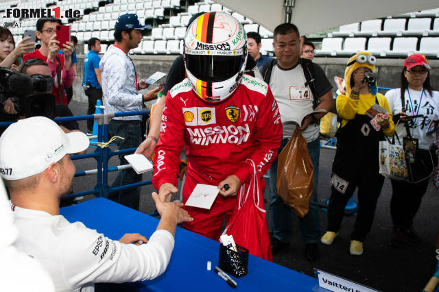 Foto zur News: Ist das etwa ...? Nein, das ist natürlich nicht der echte Sebastian Vettel sondern ein Fan, der sich hier ein Autogramm bei Valtteri Bottas holt - glauben wir zumindest! Auf jeden Fall ist dieses Bild bei den besten Schnappschüssen des Japan-GP 2019 ganz weit vorne.