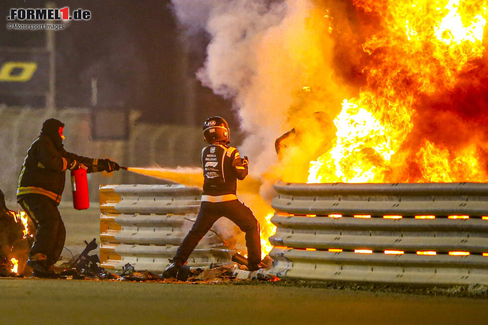 Foto zur News: Sachir 2020: Das Haas-Fahrzeug von Romain Grosjean durchschlägt die Leitplanke, bricht auseinander und fängt Feuer. Grosjean wird leicht verletzt, steigt aber selbst aus, um dann von Helfern vom Feuer weggezogen zu werden.