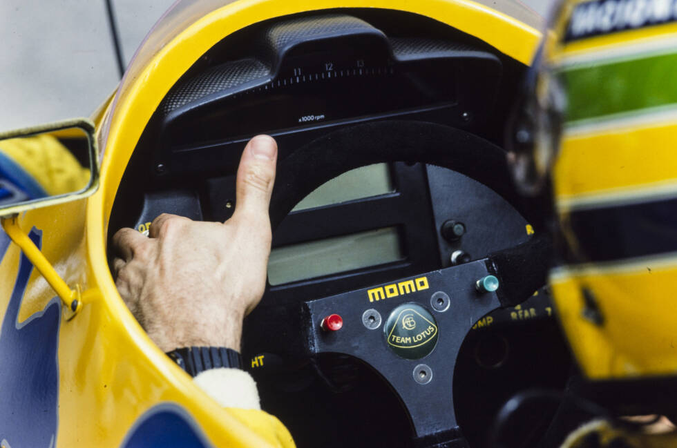 Foto zur News: Mitte der 1980er-Jahre erhalten die Fahrer erstmals Knöpfe auf ihre Lenkräder. Der Lotus 99T von 1987 zeigt einen roten und einen grünen Knopf, dazu ein digitales Display im Hintergrund. Das analoge Armaturenbrett verschwindet aus dem Formel-1-Cockpit.