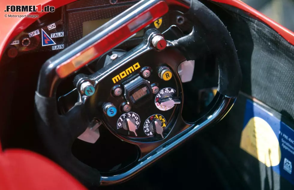 In dieser Zeit tauchen zum ersten Mal Drehschalter auf dem Formel-1-Lenkrad auf, wie hier am Ferrari 310 von 1996. Nun sind auch ein kleines Display und die Drehzahlanzeige direkt ins Lenkrad integriert, dazu Knöpfe für den Funkverkehr (R) und den Boxengassenlimiter (L). Komplett rund ist nun kein Lenkrad mehr. Foto zur News: In dieser Zeit tauchen zum ersten Mal Drehschalter auf dem Formel-1-Lenkrad auf, wie hier am Ferrari 310 von 1996. Nun sind auch ein kleines Display und die Drehzahlanzeige direkt ins Lenkrad integriert, dazu Knöpfe für den Funkverkehr (R) und den Boxengassenlimiter (L). Komplett rund ist nun kein Lenkrad mehr.