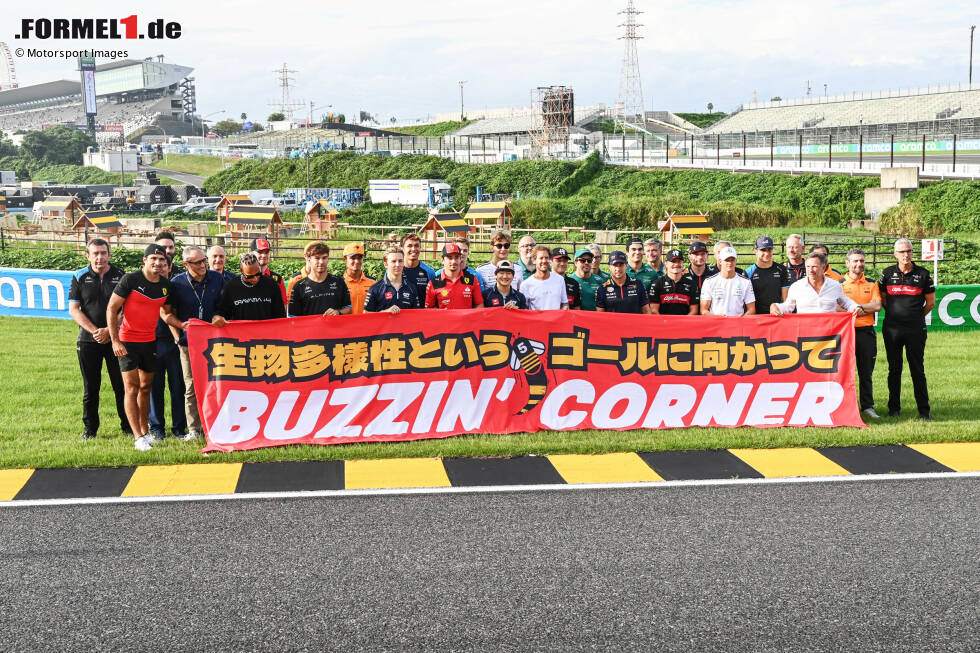 Foto zur News: "Buzzin' Corner": Sebastian Vettel und die Formel-1-Fahrer 2023 bei der Vorstellung des Insekten-Projekts von Vettel im Infield des Suzuka International Racing Course in Japan. Die schwarz-gelben Randsteine sind kein Zufall, sondern ...
