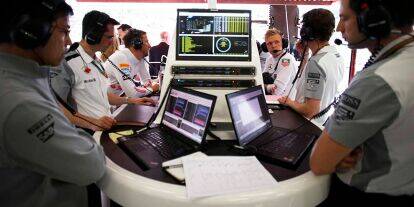 Foto zur News: Blick in eine typische Formel-1-Garage: Ingenieure und Fahrer beim Sichten und Analysieren der Daten