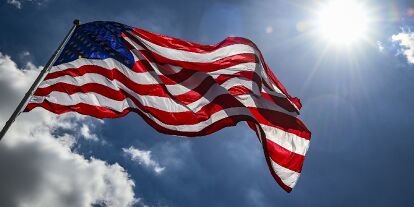 Foto zur News: Die US-amerikanische Flagge weht im Wind an der Rennstrecke