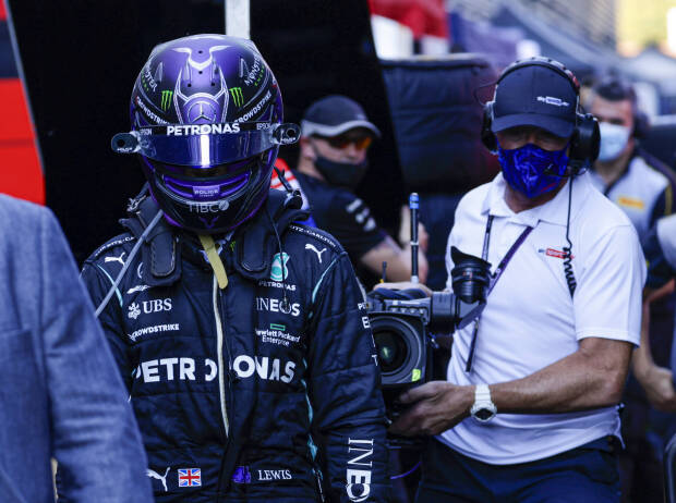 Lewis Hamilton (Mercedes) geht nach dem Crash mit Max Verstappen (Red Bull) beim Grand Prix von Italien in Monza 2021 enttäuscht zurück an die Box und wird dabei von einem Kameramann verfolgt