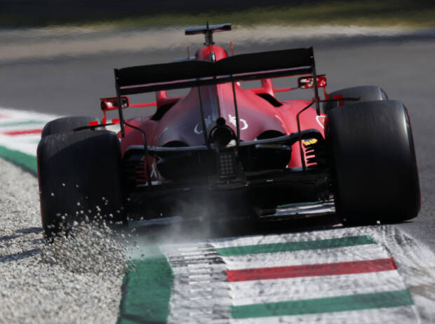 Heckansicht von Charles Leclerc (Ferrari), der beim Durchfahren einer Kurve in Monza 2021 über den Randstein Kieselsteine aufwirbelt Heckansicht von Charles Leclerc (Ferrari), der beim Durchfahren einer Kurve in Monza 2021 über den Randstein Kieselsteine aufwirbelt